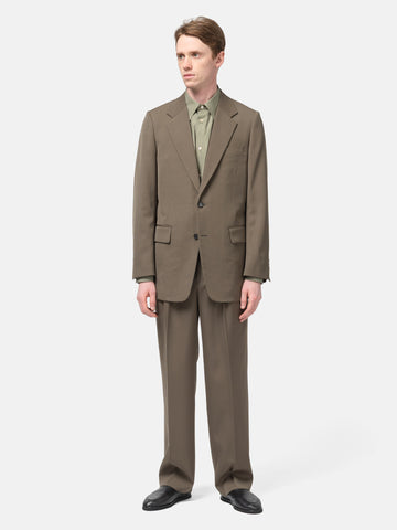 Model standing in studio wearing the AURALEE Light Wool Max Gabardine Jacket Dark in Olive Brown
