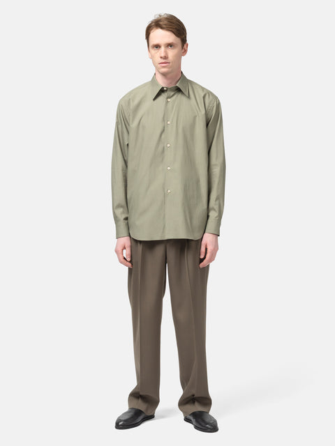 Model standing in studio wearing the AURALEE Washed Finx Twill Shirt in Olive
