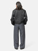 Rear view of the model wearing LEMAIRE Pleated Tailored Pants Carbon