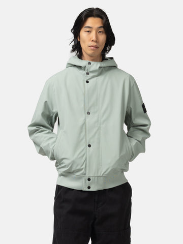 Half body shot of the model wearing the Stone Island Light Soft Shell-R_E.Dye® Technology Hooded Jacket Sage