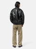 Rear shot of the Model standing in studio wearing the cotton denim 5 pocket wide pants in brown from URU