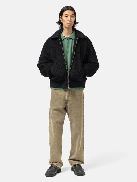 Model standing in studio wearing the wool boa zip-up blouson from URU.