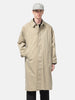 Half body shot of the Model standing in studio wearing the UNLIKELY Balmacaan Coat in Beige buttoned up