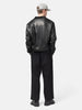 Rear view of the Model standing in studio wearing the UNLIKELY Skater's Work Pants in Black