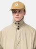 Shot in studio of the UNLIKELY Team Cap in Beige worn by the model