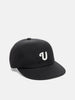 Shot in studio of the UNLIKELY Team Cap in Black