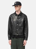 Half body shot of the Model standing in studio wearing the UNLIKELY Zero Leather Trucker JKT in Black