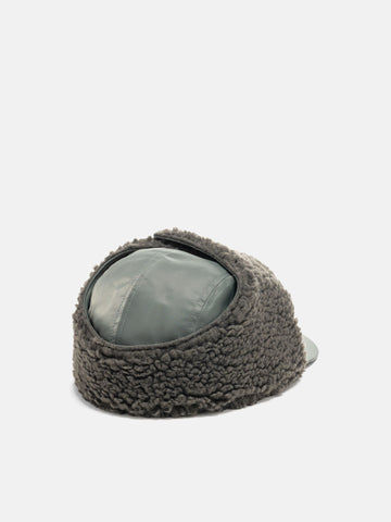 Rear view of the WTAPS AVT Cap Nylon Satin Cordura Olive Drab with ear flap attached