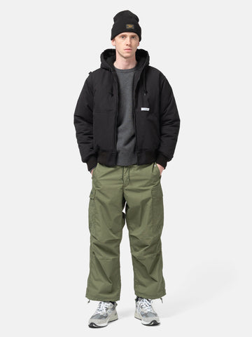 Model standing in studio wearing the WTAPS MILT9601  Trousers NYCO Weather in Olive Drab