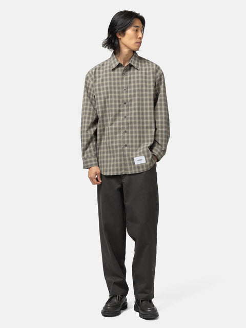 full body shot of the model wearing the WTAPS Txt 01 / LS / Poly. Broadcloth. Textile. Of Olive Drab